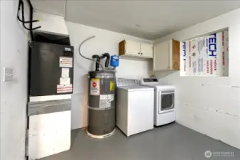 Mechanical corner of garage includes laundry area.