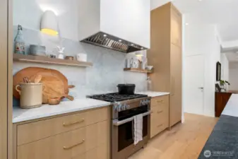 Gourmet kitchen featuring premium Miele appliances, elegant marble backsplash, and custom cabinetry accented with solid bronze Rocky Mountain Hardware—where luxury meets functionality in every detail.
