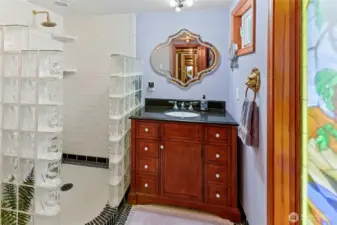 Main floor bath has custom tile work and a lovely stained glass window that is private, and lets light in!