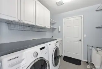 The laundry room and access to the garage (which has 3 bays, epoxy floors and an EV charger).