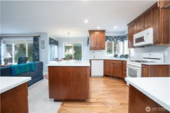 This perspective showcases the kitchen’s open flow, modern quartz surfaces, and classic beech wood cabinetry—perfect for cooking and gathering.