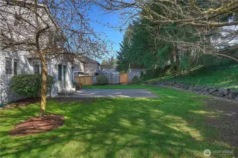 The level backyard and cement patio create a functional and inviting outdoor space for all your activities.