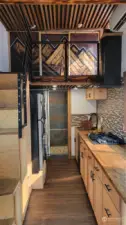 The interior of the tiny home is an absolute work of art! The kitchen has butcher block counters and tile backsplash, full size refrigerator, 5 burner cooktop, microwave and dishwasher. Upstairs the sliding doors hide the bedroom and give privacy. There is also a mini split for heating and cooling.