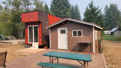 The fronts of the tiny home and bunkhouse with the two decks.