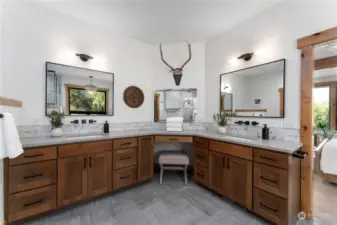 Main level Primary Bedroom Bathroom w/ dual sinks, radiant heated ceramic tile floors, quartz countertops, a stand alone tub, electric fireplace and custom tile shower w/ Moen FGF faucet sensor system.