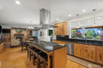 Gourmet kitchen with Wolf 6-burner propane range looks out to living room and sunroom