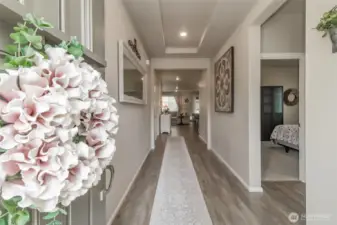 Front entry view down the hallway, with 2 bedrooms and a full bathroom on the right