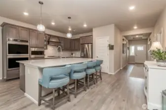 View of entry down hallway to living space and wide-open floor plan