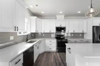 Sleek and sophisticated, this gourmet kitchen boasts high-end finishes, a large island bar and quartz countertops