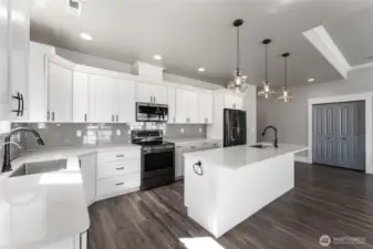Designed with style and function in mind, this kitchen showcases custom cabinetry, luxurious quartz surfaces, and premium appliances under the glow of designer lighting