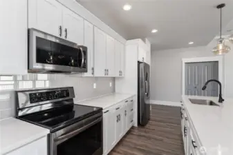 Modern elegance defines this kitchen with its handcrafted cabinetry, polished quartz countertops, and professional-grade appliances