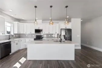The heart of the home—this stunning kitchen features a spacious island with an eating bar, perfect for casual dining, entertaining, or gathering with family and friends amidst luxury finishes and sleek design