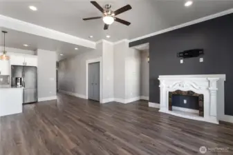 This cozy living room, bathed in natural light from large windows, seamlessly connects to the open concept floor plan—offering a perfect blend of comfort, style, and spacious flow