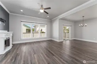 This gorgeous living room, bathed in natural light from large windows, seamlessly connects to the open concept floor plan—offering a perfect blend of comfort, style, and spacious flow