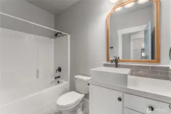 Impeccably finished, the guest bath combines tasteful tile flooring and backsplash with upscale designer touches for a polished look