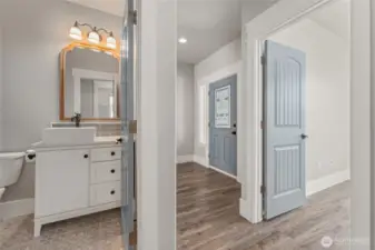 This well-appointed guest bathroom features chic tile work on the floors and backsplash, complemented by sophisticated designer details