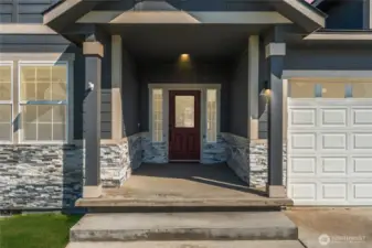 The covered front entry exudes charm and elegance, enhanced by rich stone accents and thoughtful architectural design
