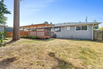 Fenced backyard with covered deck.