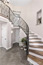 Grand spiral staircase leads to upstairs bedrooms and laundry room.
