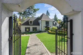 With charming wrought iron gate and lighted cobblestone paths.