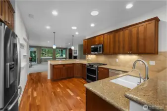 Beautifully updated kitchen featuring quartz countertops, hardwood floors, a new gas oven and range, dishwasher, and microwave. Upgraded cabinetry with pull-out shelves and a charming eat-in space make this kitchen both stylish and functional.