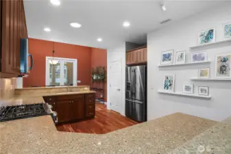 Beautifully updated kitchen featuring quartz countertops, hardwood floors, a new gas oven and range, dishwasher, and microwave. Upgraded cabinetry with pull-out shelves and a charming eat-in space make this kitchen both stylish and functional.