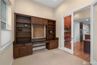 Bright and spacious den/flex space featuring custom built-in cabinets and a desk perfect for a home office, study, or creative workspace.