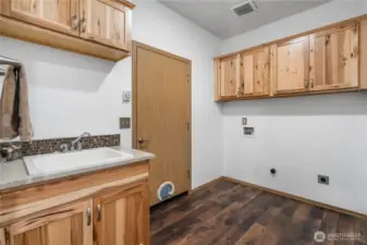Spacious laundry room with a utility sink and additional storage closets