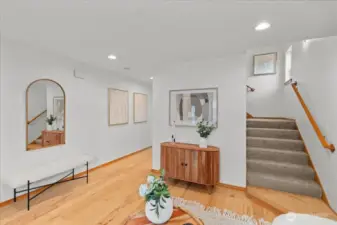 Front living room featuring a large window for natural light and a direct view of the entry door. laminate flooring continues throughout the main living area.