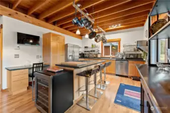 Chef's Kitchen offers food theatre seating! Propane Range and oven. Hardwood floors. Double door Refrigerator, Microwave Wine cooler, D.W., Garbage disposal.