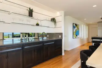 Wet bar in the dining room has sink and dishwasher.