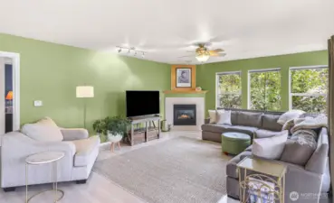 Another view of the living room with cozy gas fireplace and ceiling fan.