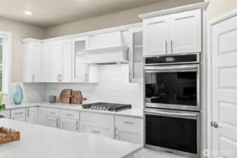 Double ovens, built-in lower microwave, gas cooktop, pantry, and plenty of cabinet storage.