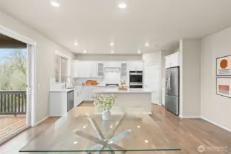 Large, open concept kitchen and dining room with a sliding glass door to the back deck.