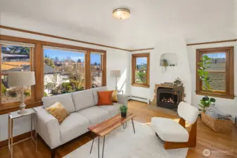Gorgeous living room with newly finished oak hardwood floor and a inviting wood fireplace, with sweeping views of Cascades, Mt Rainier, the Ship Canal bridge and surrounding areas