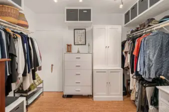 Large walk-in closet with built-ins & cork flooring. Door on far wall left to water heater, forced air electric furnace and additional storage.
