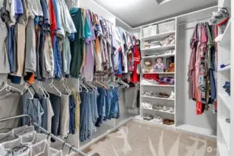 Large walk in closet in the primary bedroom with newer shelving system.