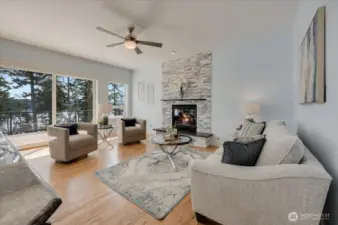 Main floor living room with large windows, slider to deck and gas fireplace