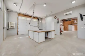 Wood shop with vacuum system, large workbench/runout table with storage, power and table saw