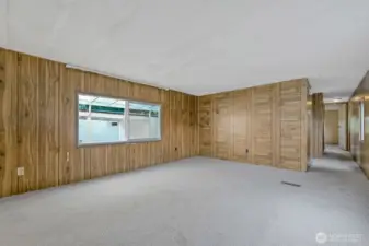 Spacious living room with large windows that bring in natural light, creating a bright and open atmosphere.