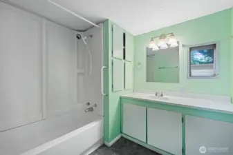 Full bathroom with tub/shower combo, extended vanity, and built-in storage cabinets.