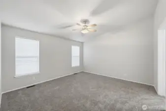 Spacious primary bedroom with new carpet.