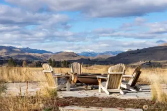 A beautiful quartzite patio and elevated fire pit with mountain views is a short walk from the home's front porch.