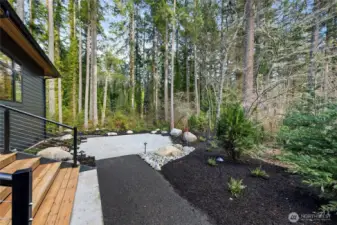 paver patio off the covered deck and into the woods of this 1 acre property