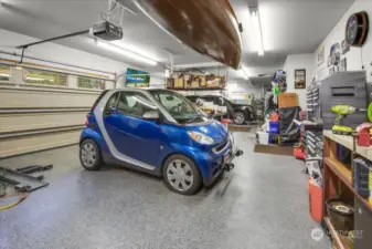 Marvel at your new 1,340 Sq. Ft. 4+ Car Dream Garage with Commercial Grade Flooring, Tons of Flourescent Lighting, Workbench and cabinets, Steel Hanging Rack and lots of wire wall shelving.