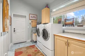 Entering from the 1,340 Sq. Ft. Garage or the Guest Hallway is this spacious Laundry Room. It hosts Upper and Lower Cabinets, a Large Pantry, 1/2 Bath for quick stops, Skylight, Front Load GE Washer/Dryer with Pedestals, Transom Window and a territorial view.