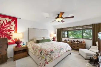 The primary bedroom will accommodate a king bed and two nightstands with room to spare. The window treatments here are woven window blinds.