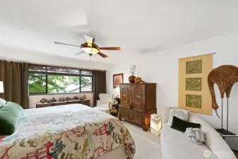 The primary bedroom is large, comfortable and has room for a king bed, two nightstands and a dresser and lowboy under the window. Here you can see the love seat that complements the space, providing a reading or relaxation area.