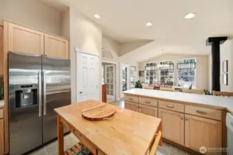 Kitchen looking towards eating bar & dining room with woodstove (pantry to the left).