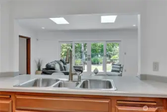 View from the kitchen to the family room through the new double gliding doors by Renewal by Anderson to the private deck & back yard. Perfect for entertaining & relaxing.